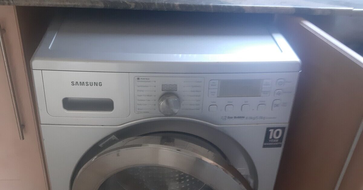 A real front-loading washing machine installed beside a kitchen counter
