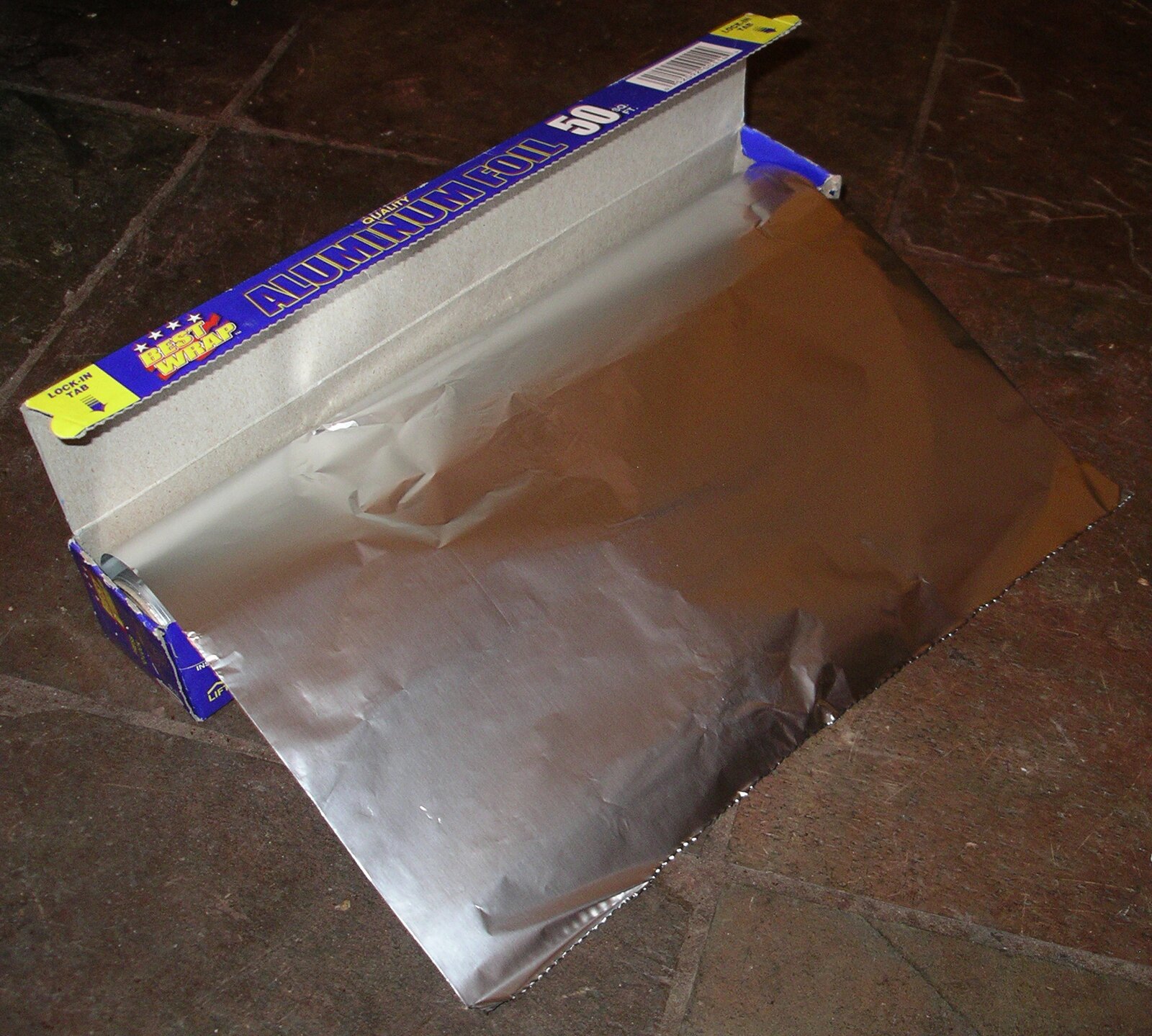 A real sheet of household aluminum foil partly unrolled from its box