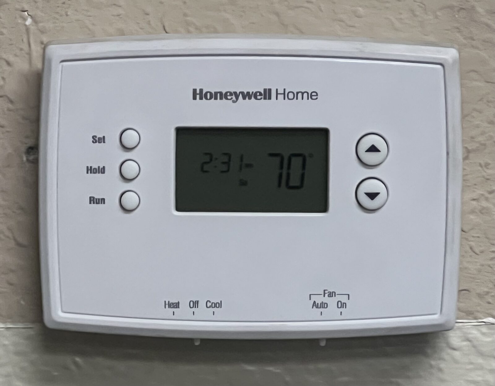 A digital home thermostat mounted on a wall