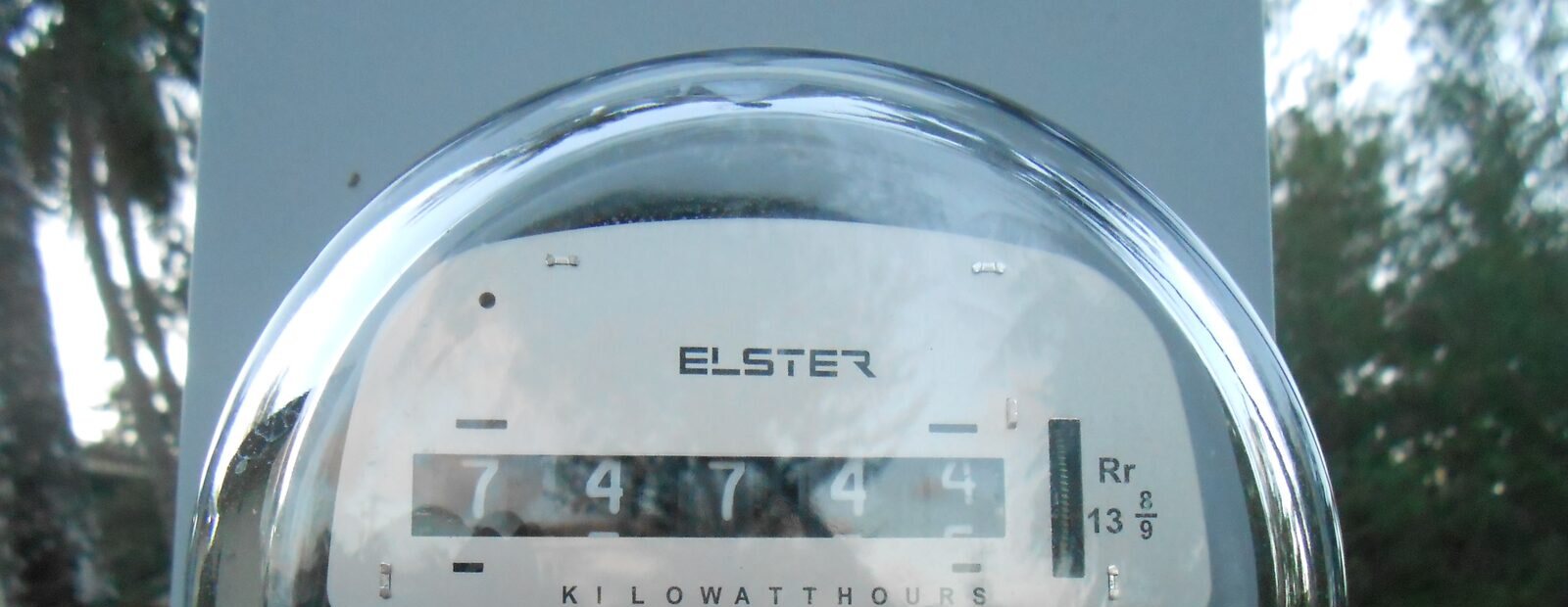 Close view of an analog residential electricity meter displaying kilowatt-hours