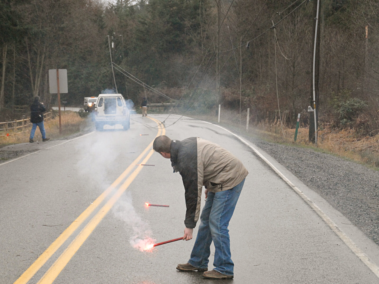 Emergency utility workers controlling traffic near downed power lines after a wind storm
