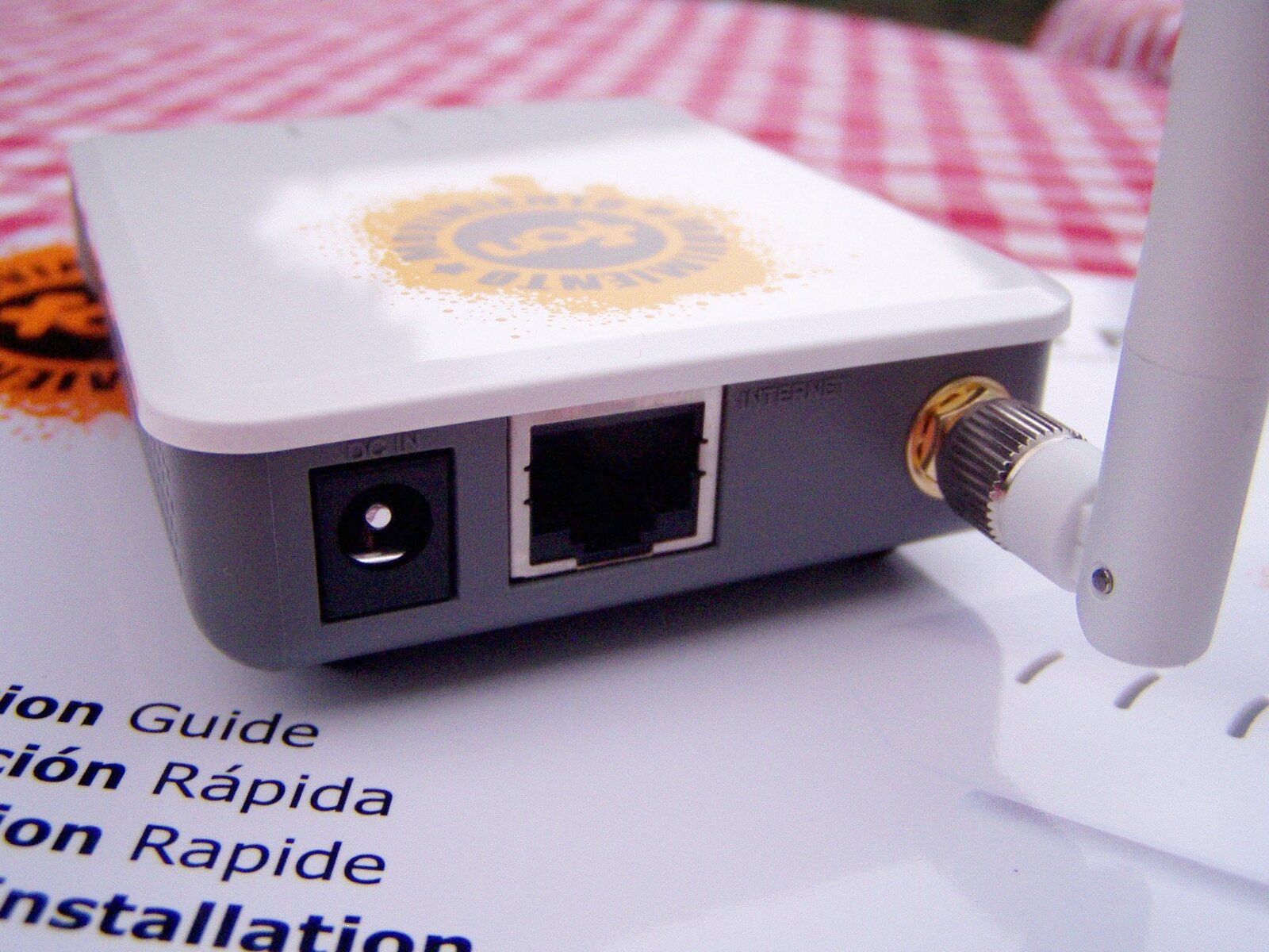 The rear of a real wireless router showing its Ethernet port, power connection, and antenna